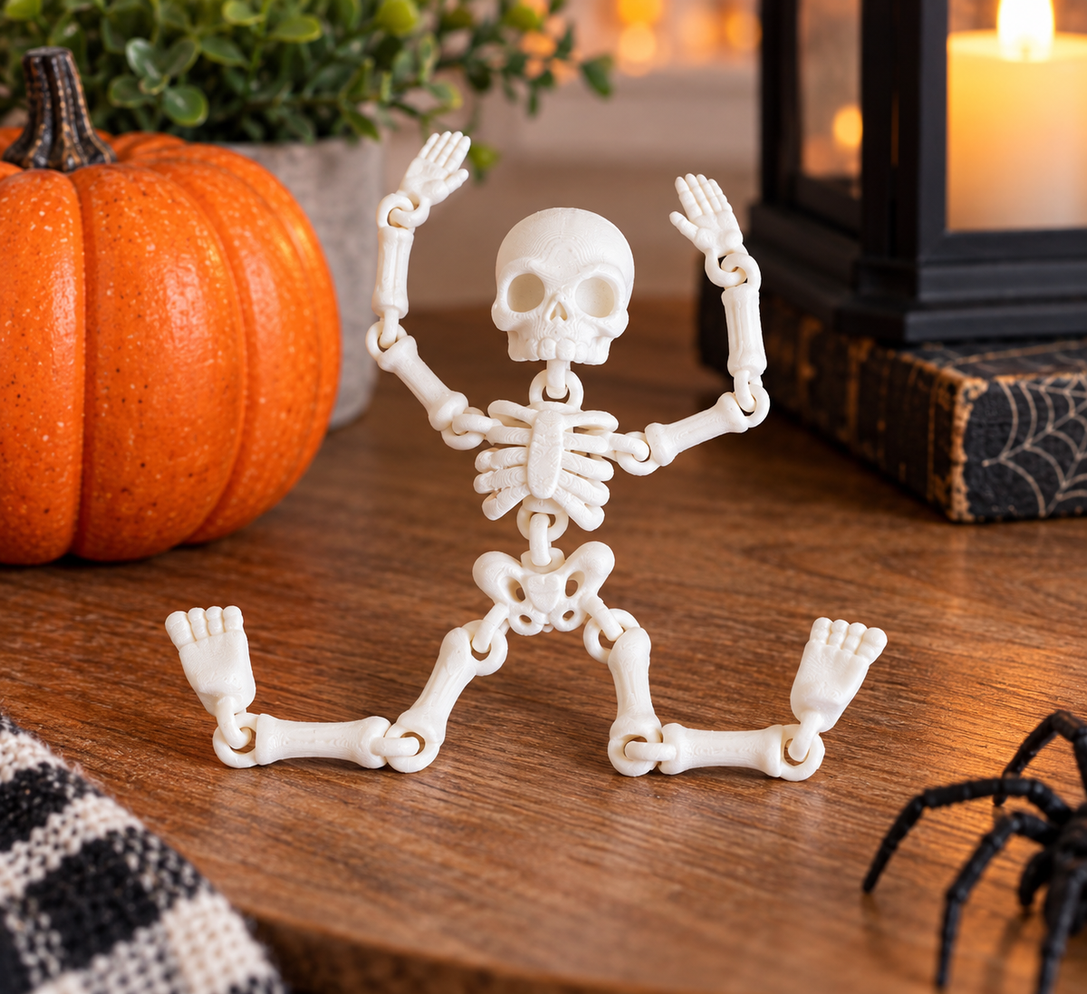 White 3D printed articulated skeleton toy in a Halloween tabletop scene