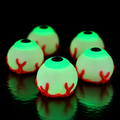 Glow in the dark 3D printed eyeball clicker on a dark background