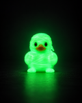 Glow in the dark 3D printed mummy duck on a dark background