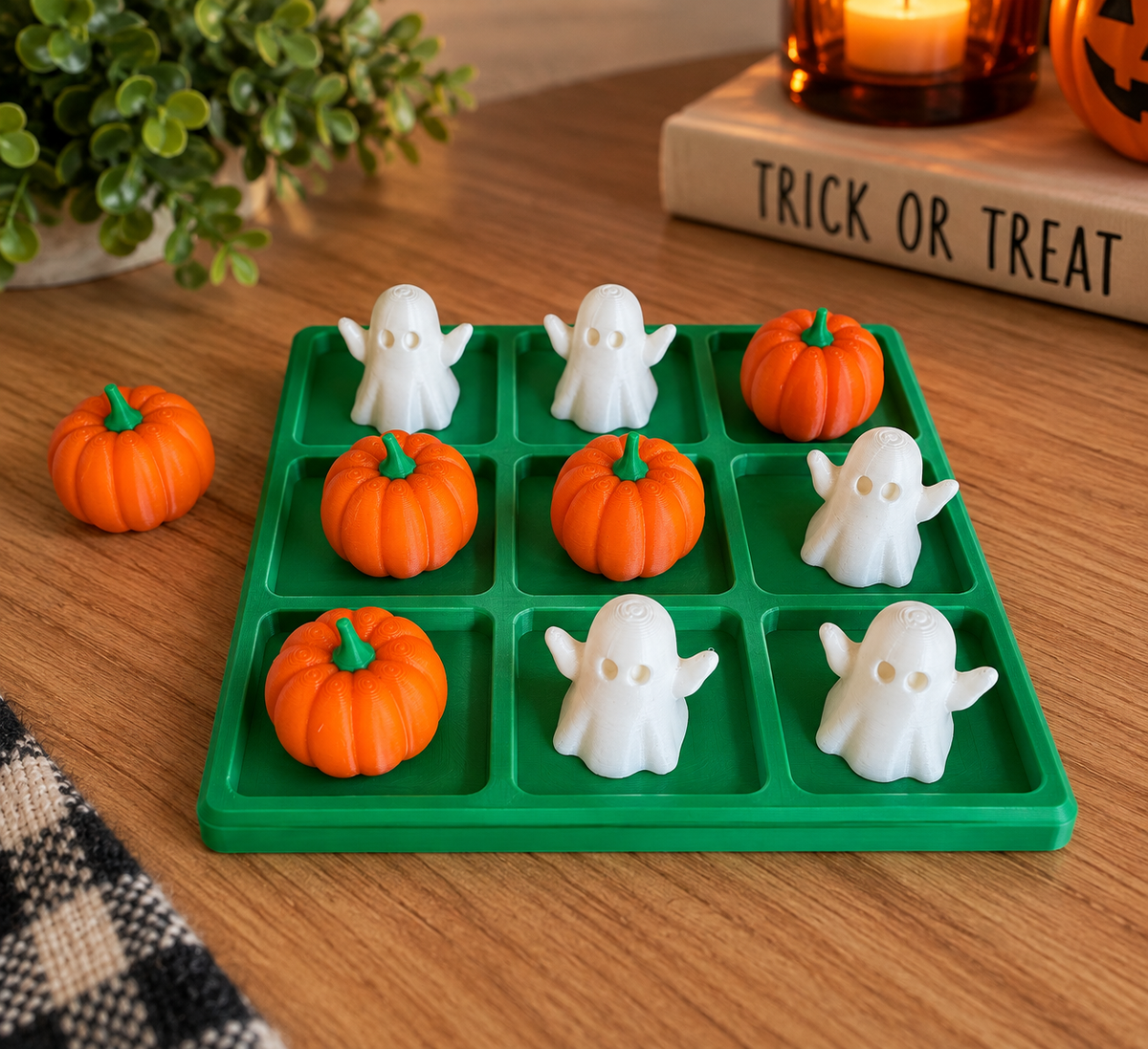 Green 3D printed Halloween tic tac toe board with orange pumpkins and white ghosts