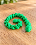 Bright green 3D printed articulated snake fidget with green eyes