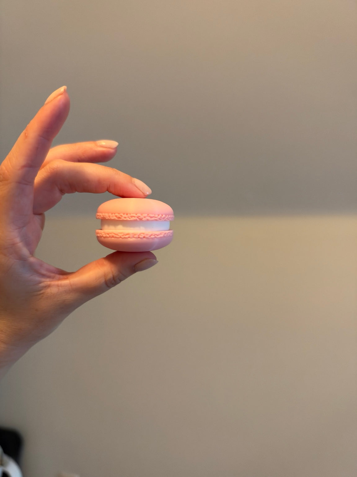 Pink 3D printed macaron clicker held in hand